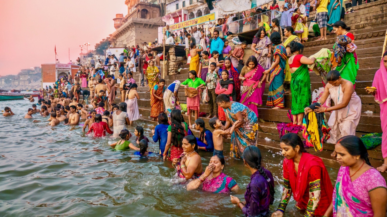 Varanasi, India - November 11, 2015. Showing the colorful traditional clothing and Hindu religious ritual of bathing in the Ganges River from the ancient ghats of Varanasi.