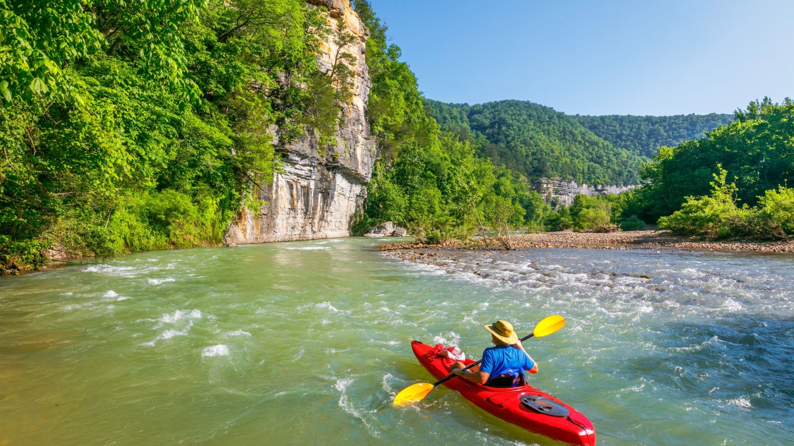 A kayaker is floating down the Buffalo River near Ponca, Arkansas.