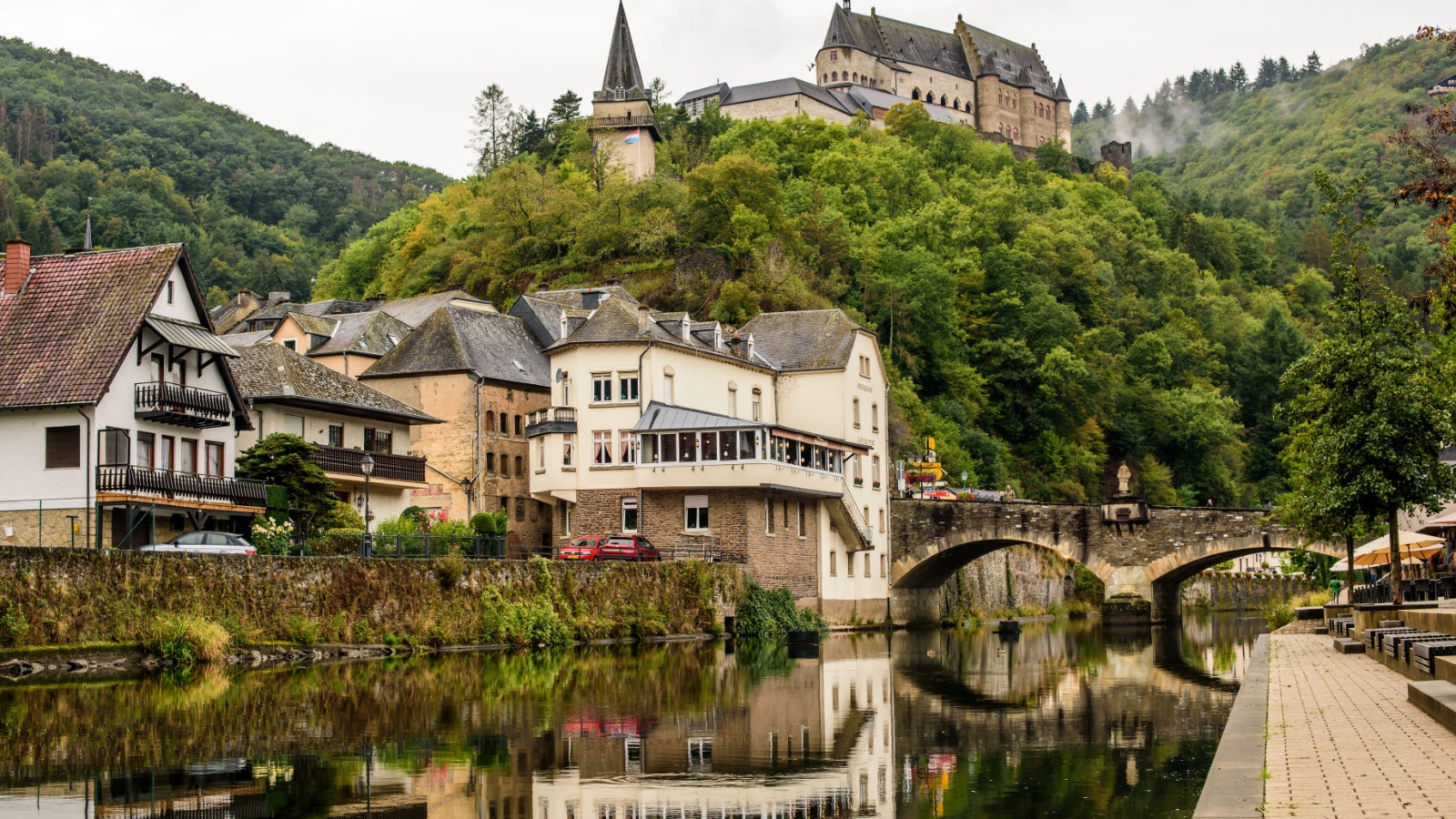 Vianden, Luxembourg - September 7, 2019: The view north-west up the river Our to the village and Vianden Castle on the hills in the background