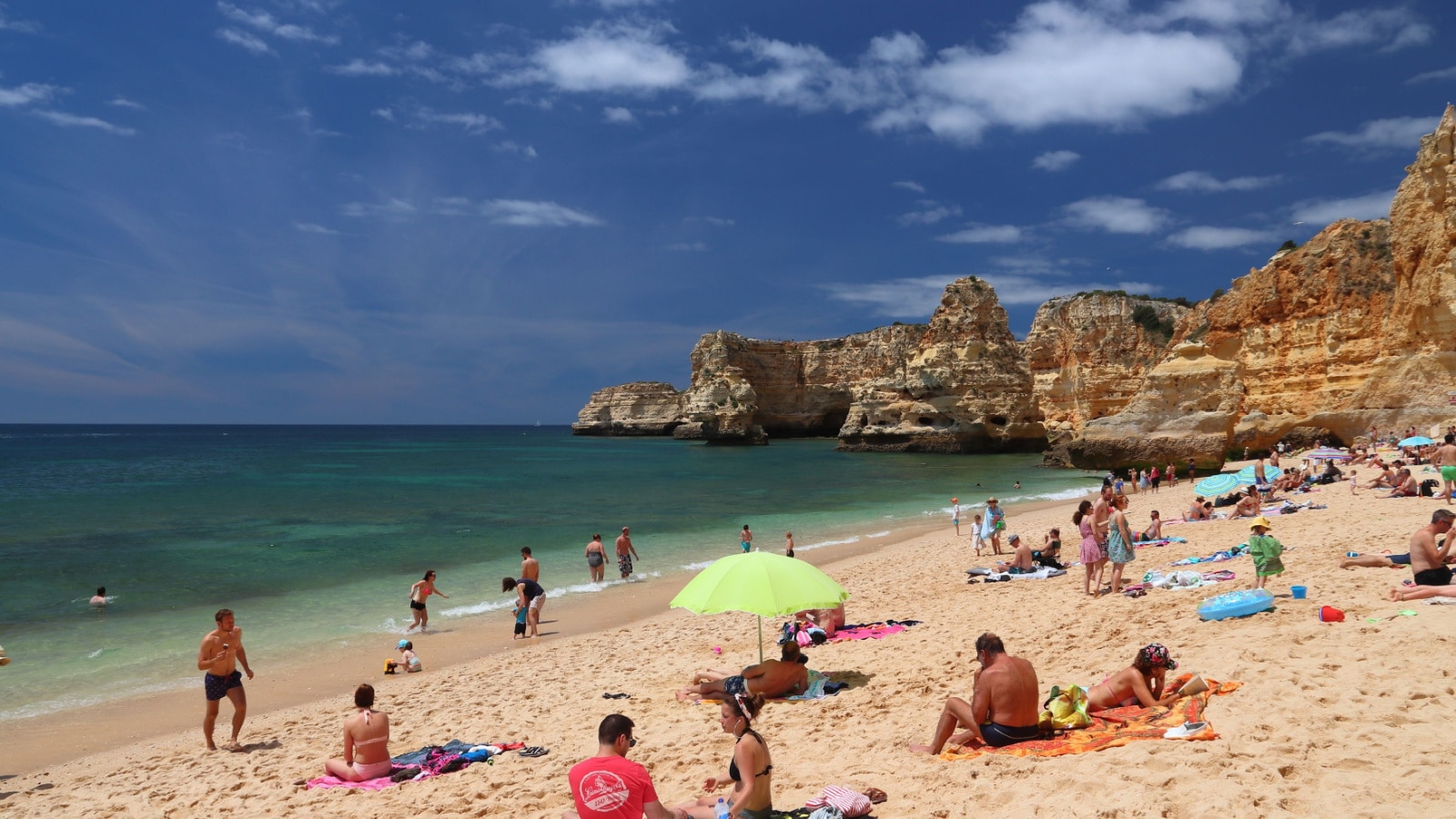 ALGARVE, PORTUGAL - MAY 31, 2018: Beachgoers visit Marinha Beach in Algarve region, Portugal. Coastal region of Algarve attracts more than 17 million tourists annually.