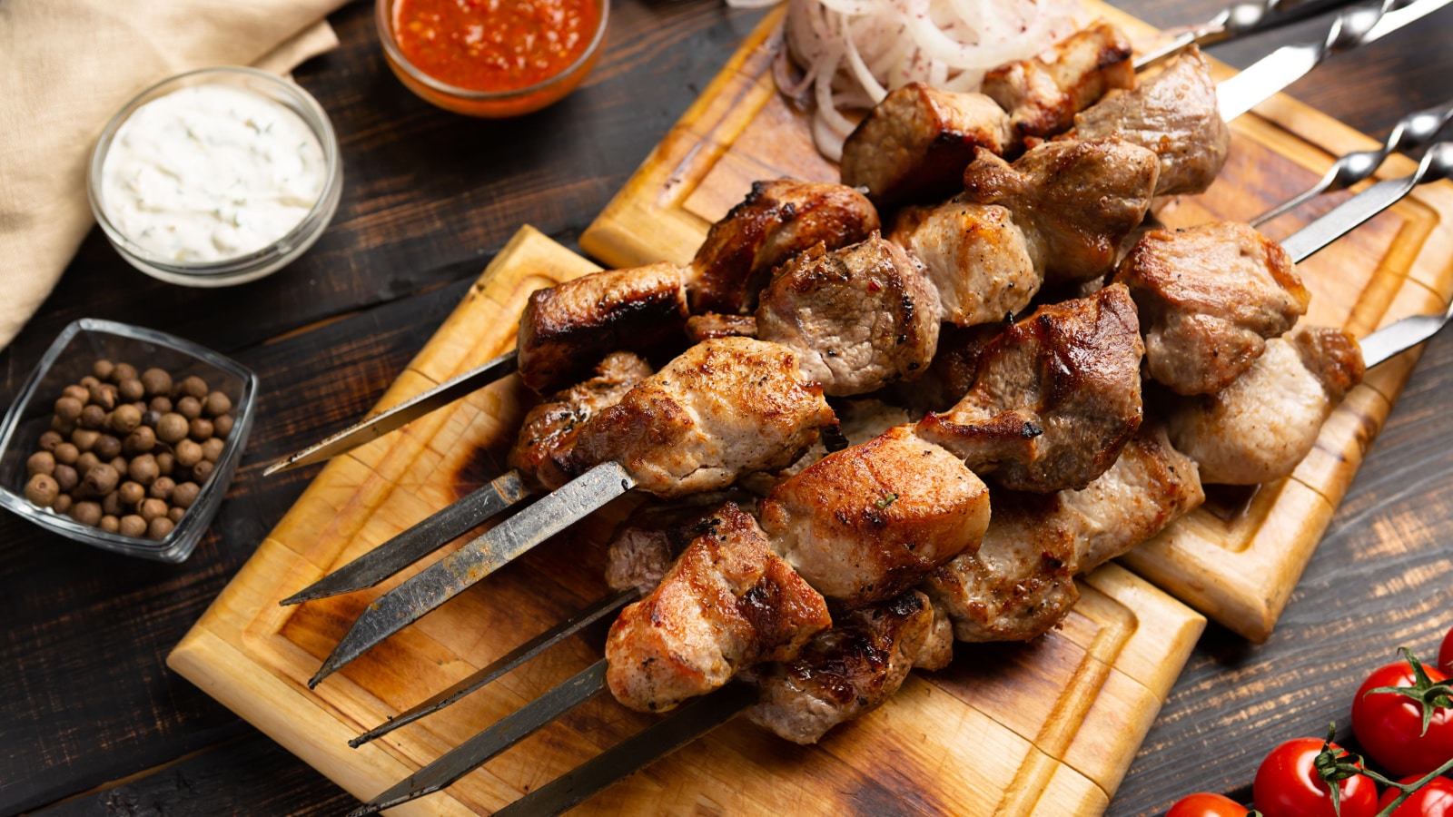 Barbecue Grilled pork shashlik kebabs meat on metal skewer on cutting board rustic style