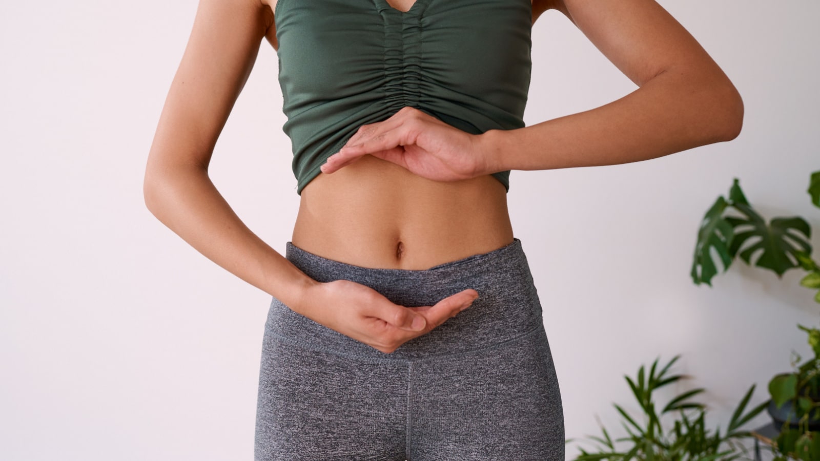 Cropped shot of a young multi-ethnic woman's stomach cupped by her hands