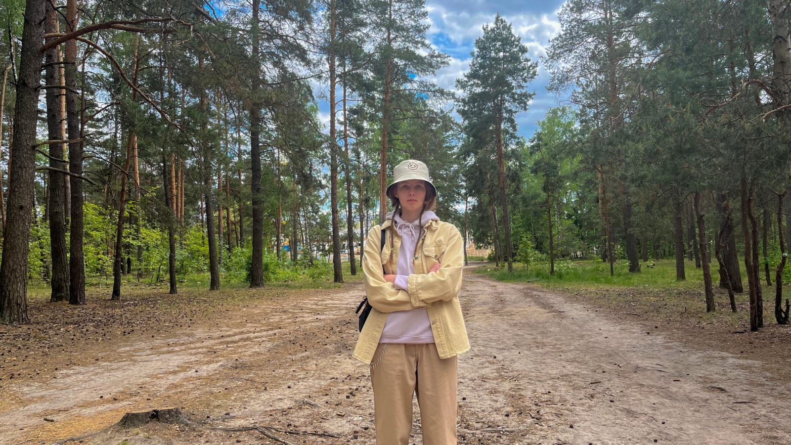 a young girl traveler stands in the forest on the trail