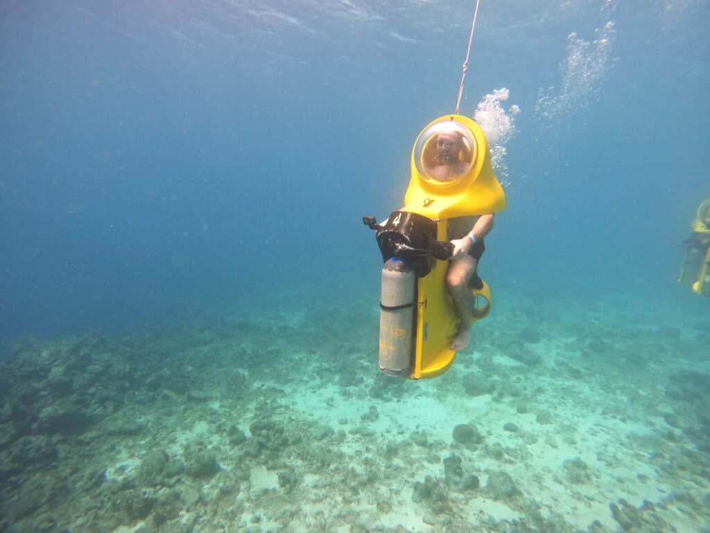 Zac riding his yellow underwater scooter in Curacao