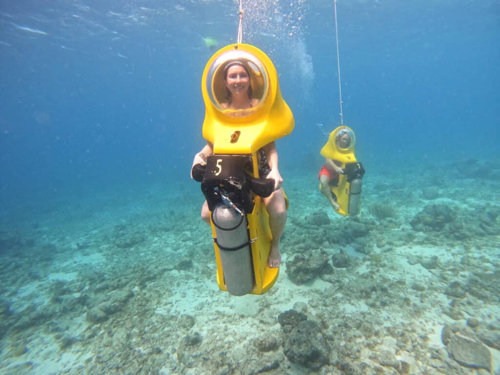 Lindsey of Have Clothes, Will Travel on her yellow underwater scooter in Curacao