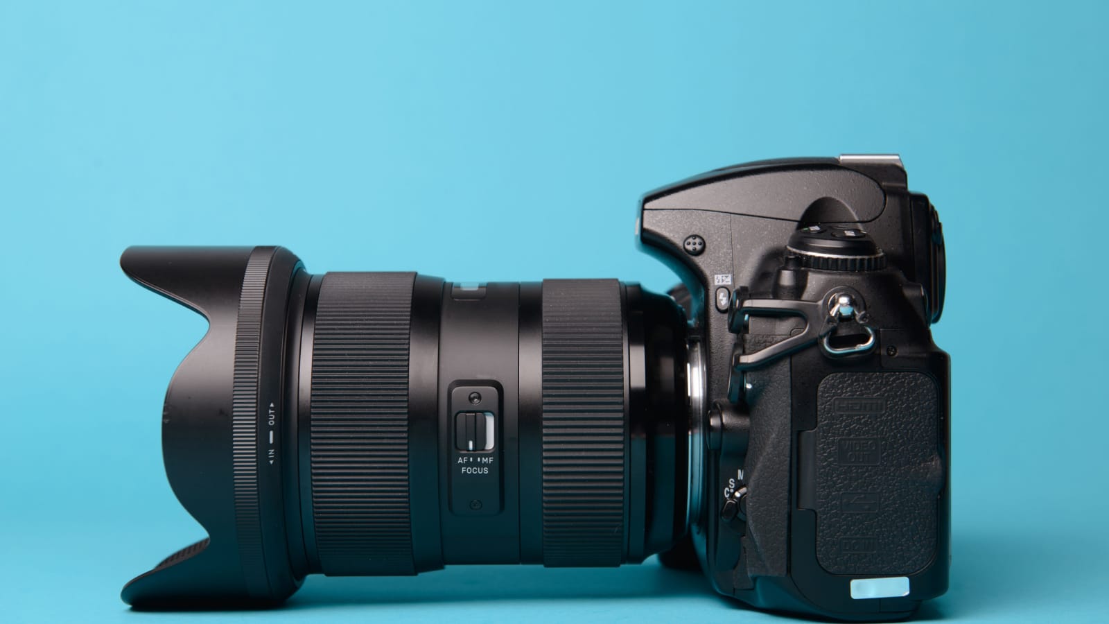 Professional modern DSLR camera against blue background