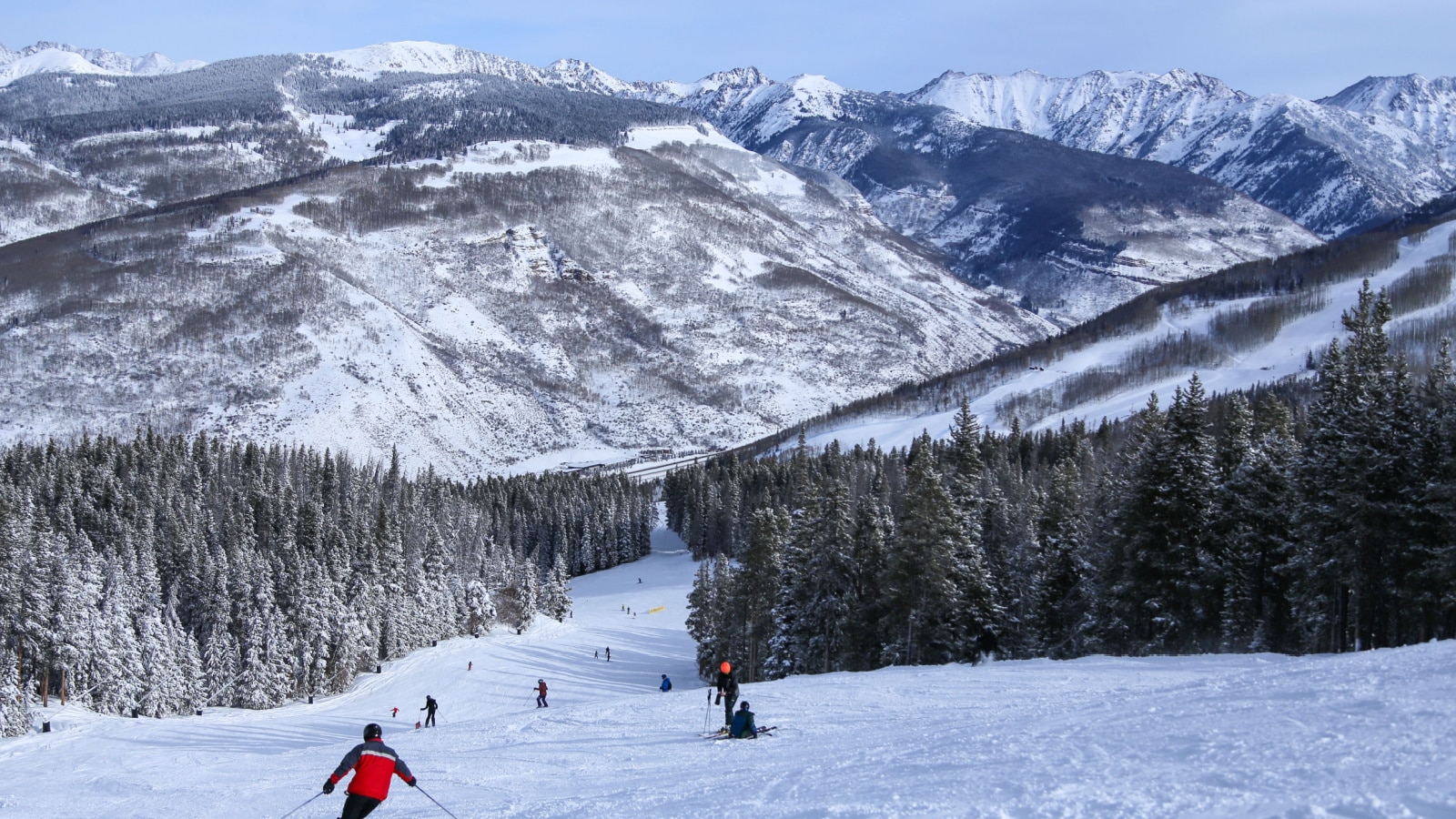 People alpine downhill skiing on trail at Vail ski resort in the Colorado Rocky Mountains in winter