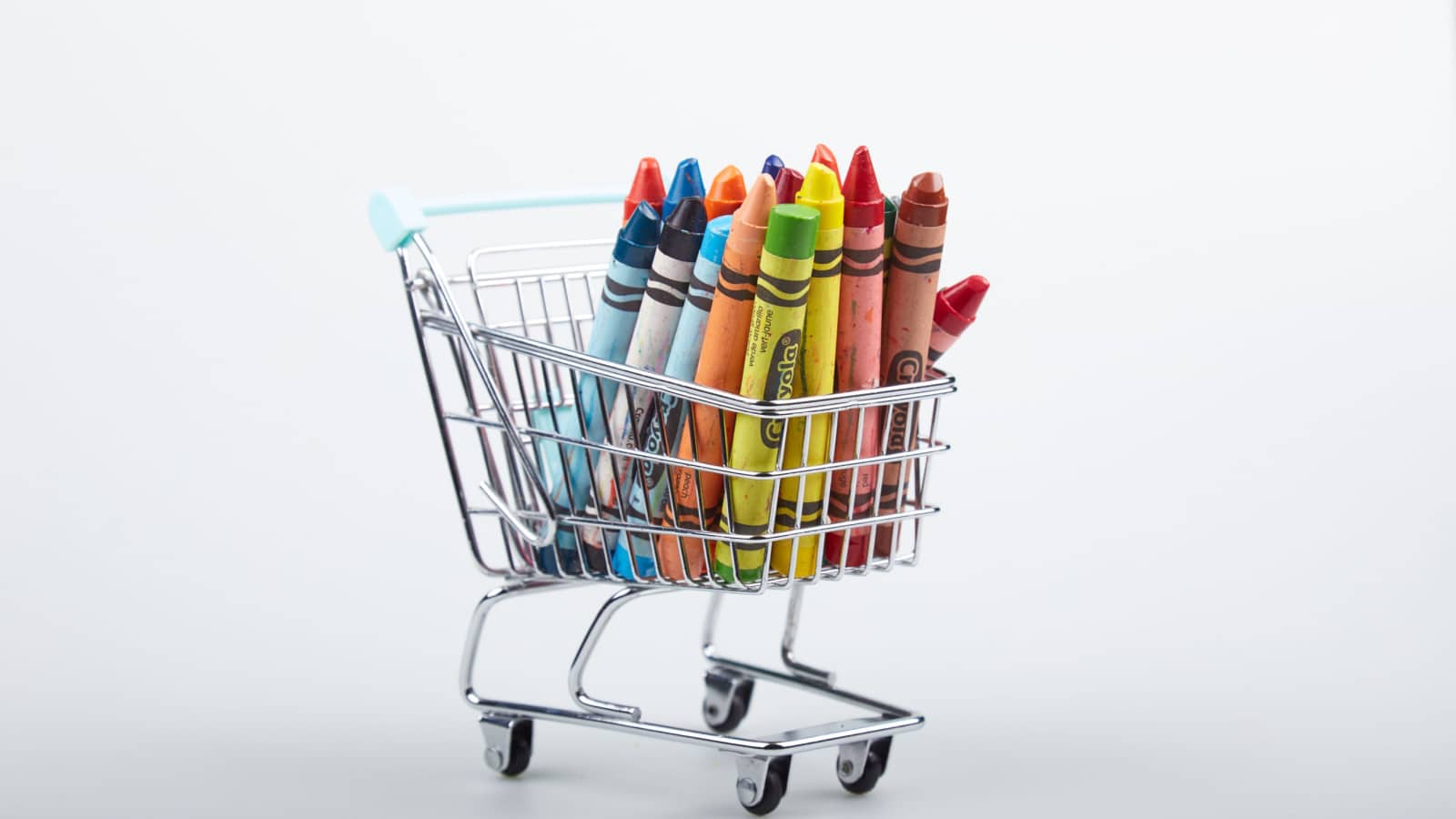 Mérida, Yucatan, México; 05-08-2022: Crayons in a shopping cart isolated on white background