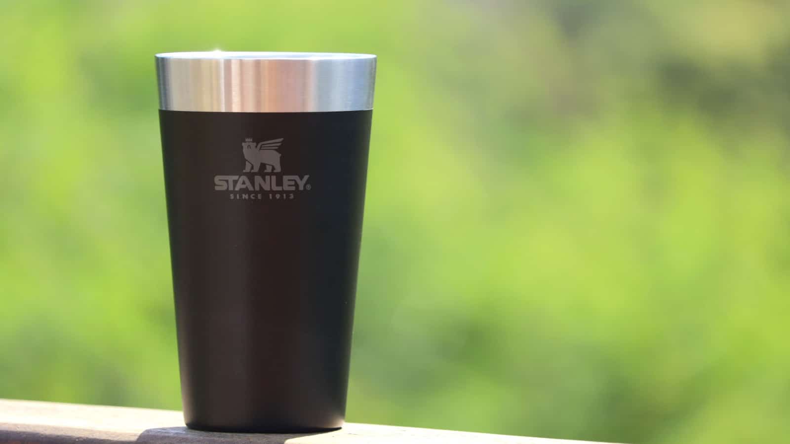 Rio de Janeiro, Brazil - March 12, 2023: Stanley black thermal cup for drinking beer, on green background