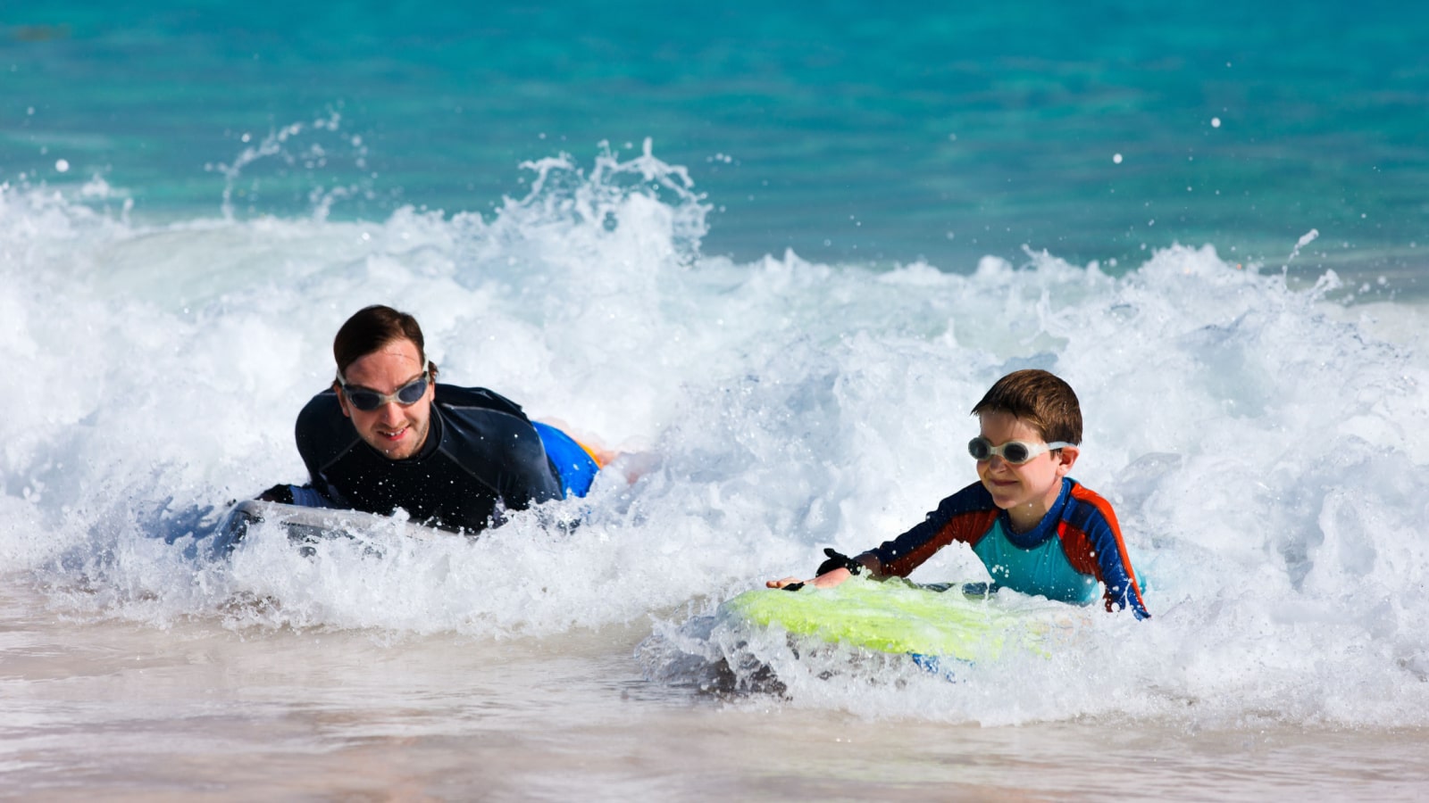 Father and son surfing on boogie boards