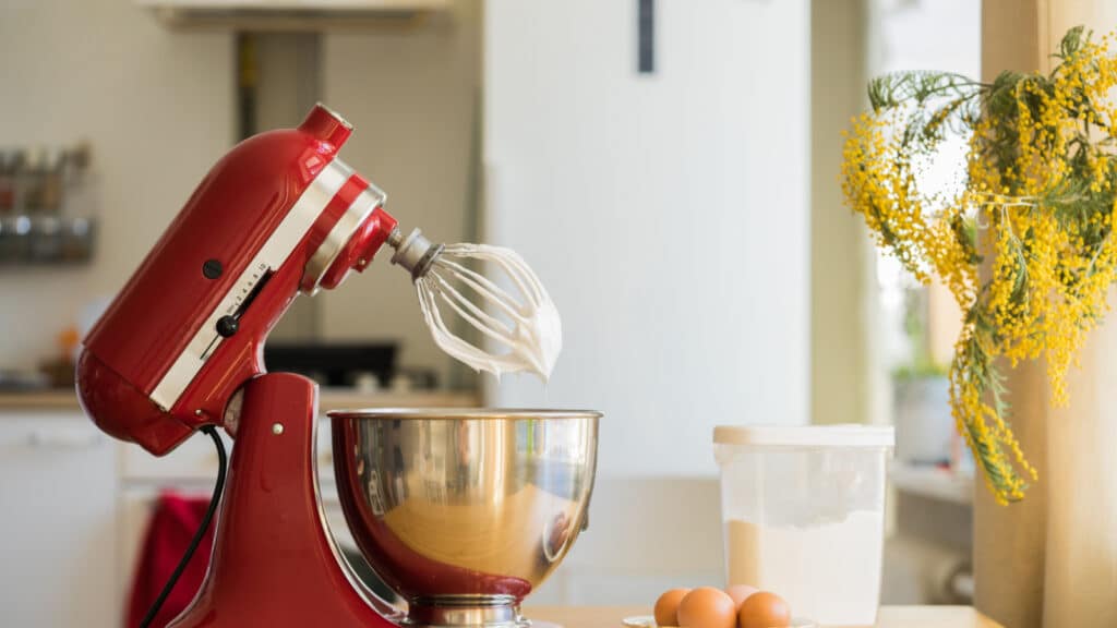 red stand mixer mixing cream