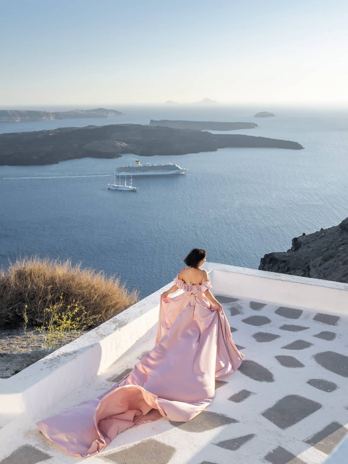 Lindsey Puls wearing a long pink dress against a white walk way