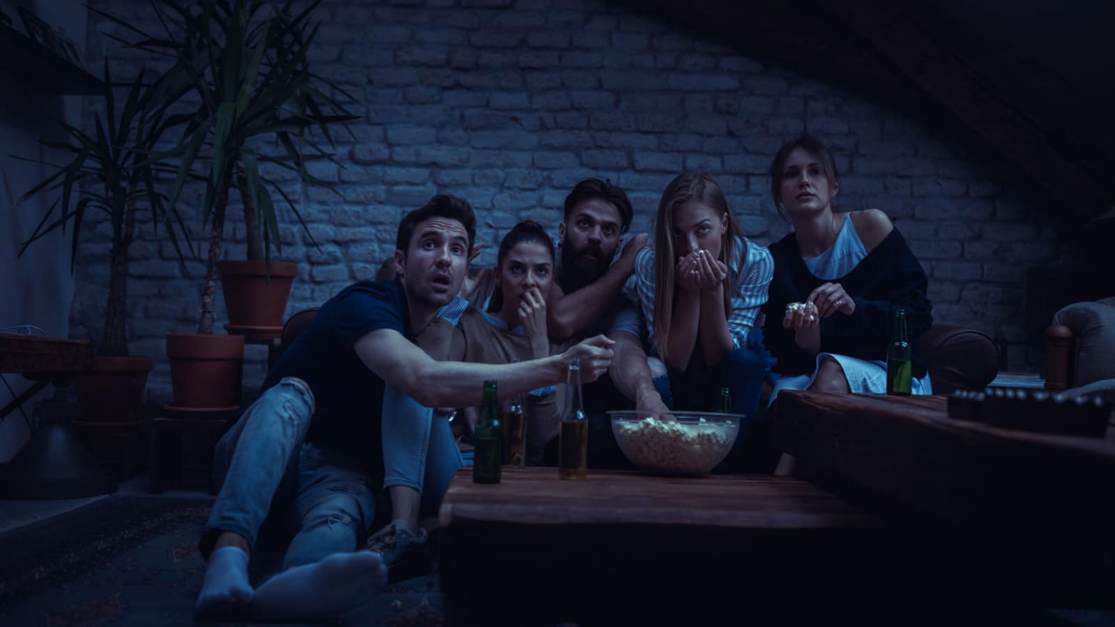 Group of friend watching scary movie at home
