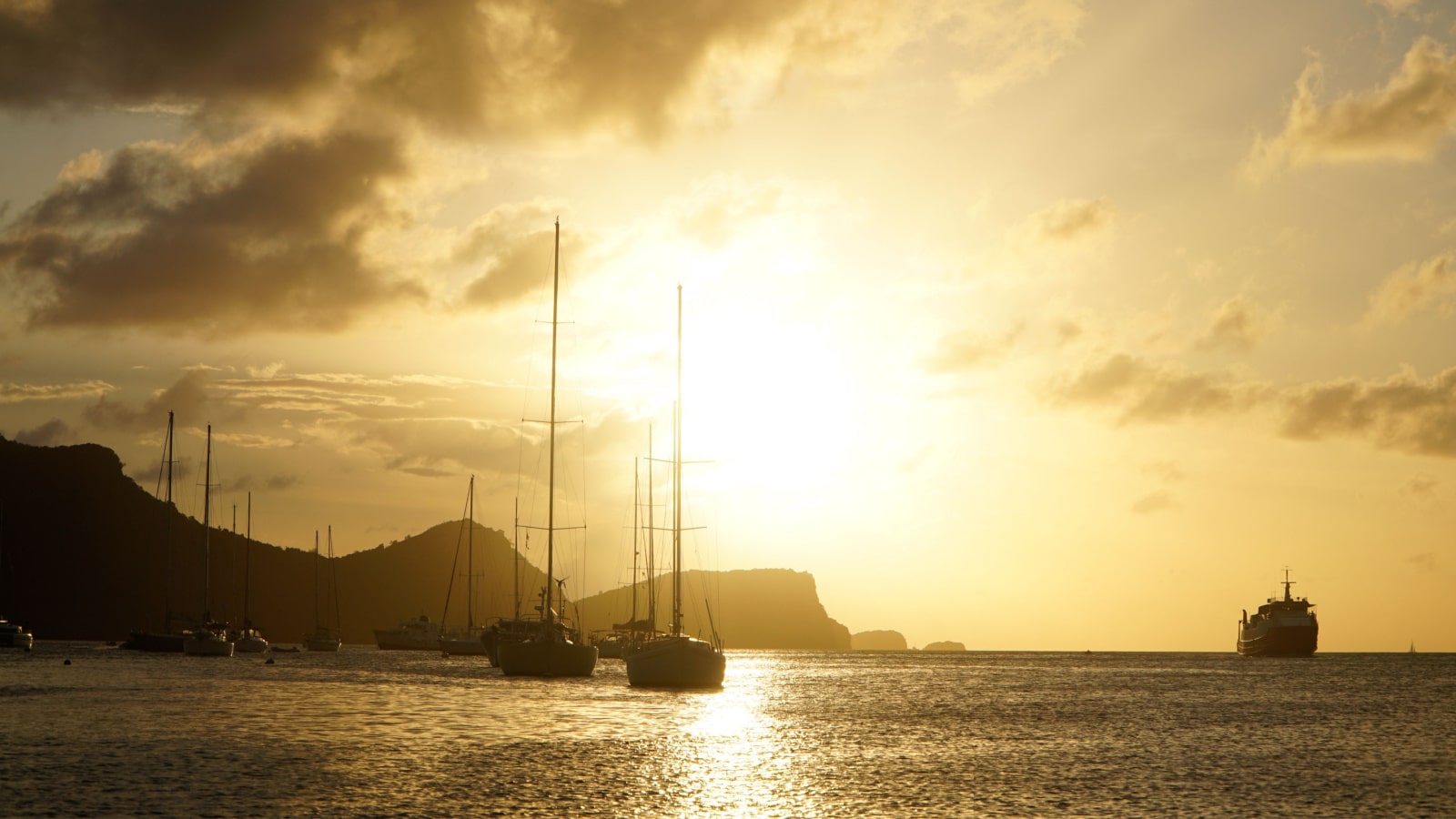 Sunset over Union Island with Sail boat yachts in the Tobago Cays near Saint Vincent and the Grenadines, Caribbean.