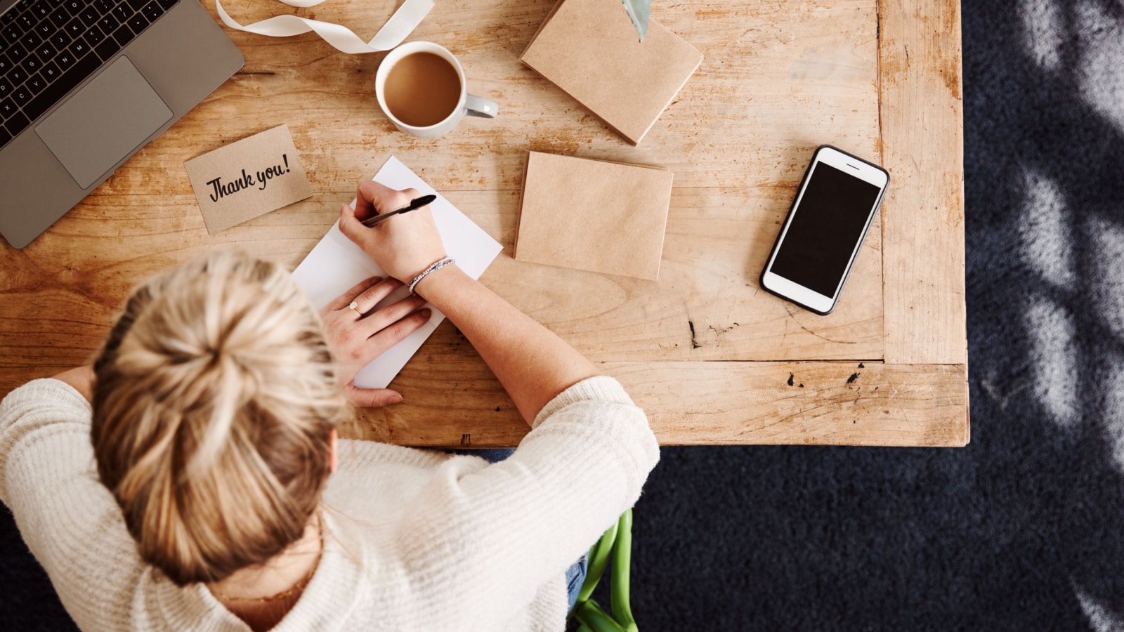 Overhead Shot Looking Down On Woman Writing In Generic Thank You Card