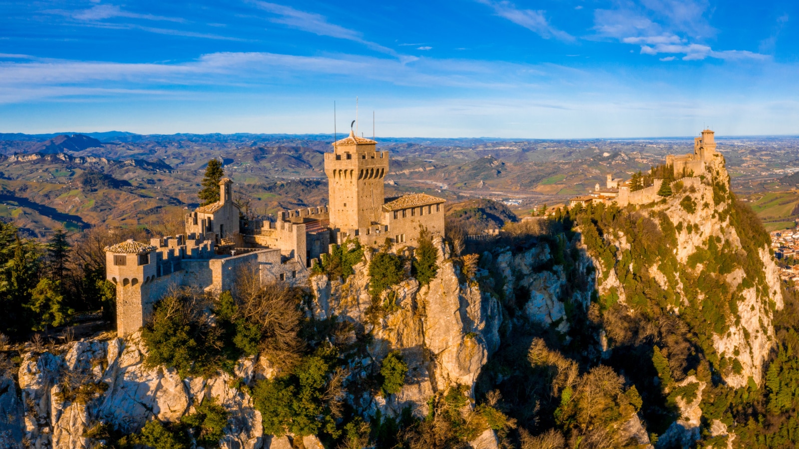 Beautiful aerial scenic view of Guaita fortress on Monte Titano with San Marino city in background at sunrise. Beautiful country of San Marino historical center. Castle on top of the hill.
