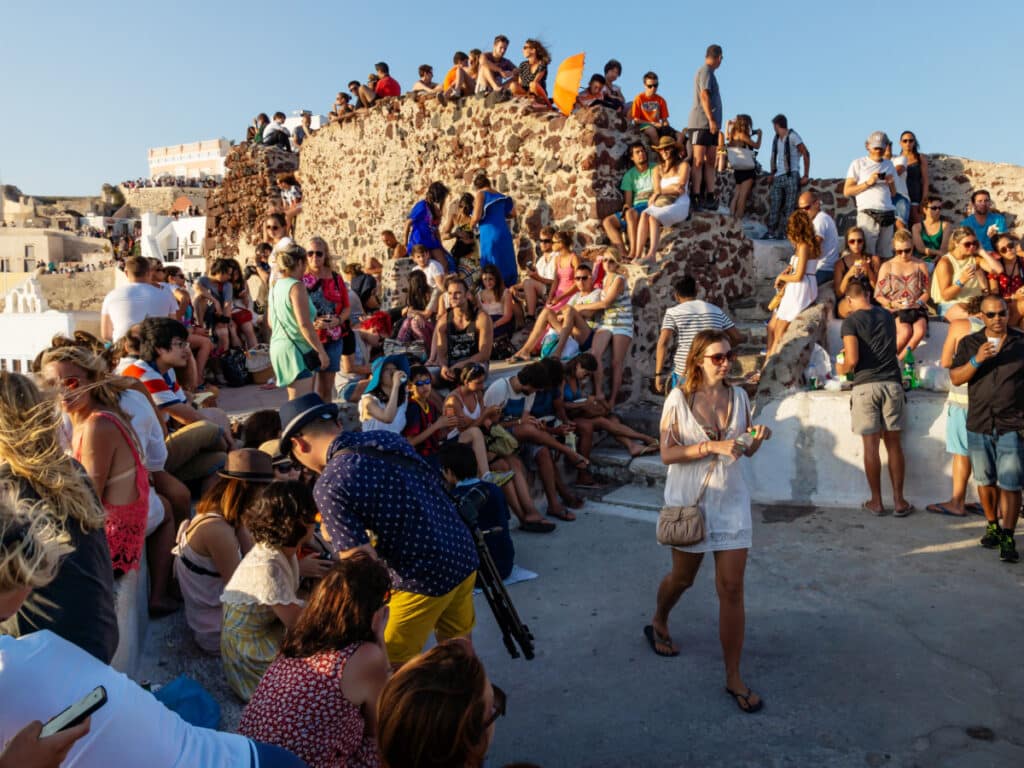 Oia, Santorini, Greece - 22 July 2014: Crowds of tourists waiting for sunset at the viewpoint on the castle