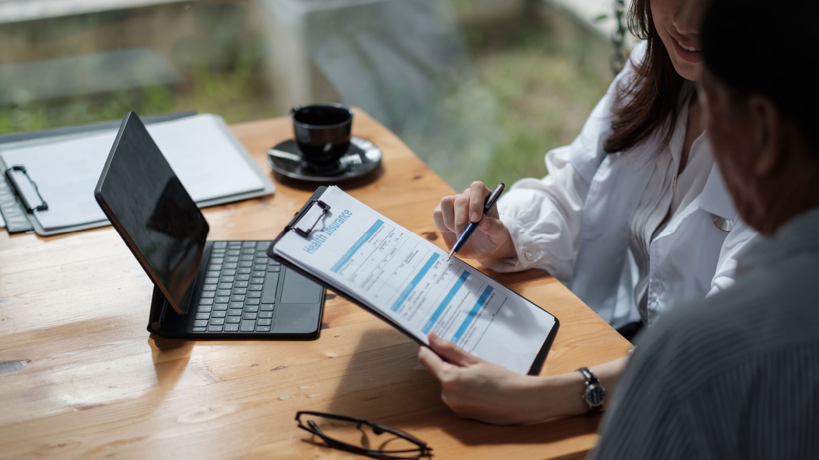 Female health insurance broker presenting his insurance benefits to businessman fill out insurance policy. To prevent future incidents.