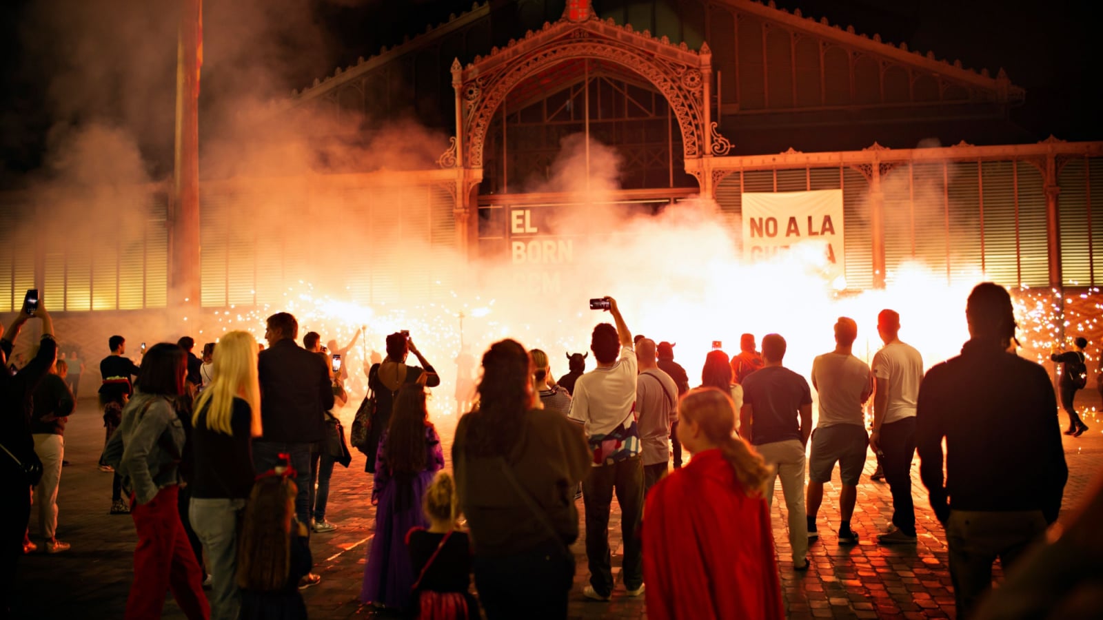 Barcelona, Spain - October 31 ,2022: Helloween celebration. Fire show on the street El Born district. People watching performance with fire and music local Spaniards.