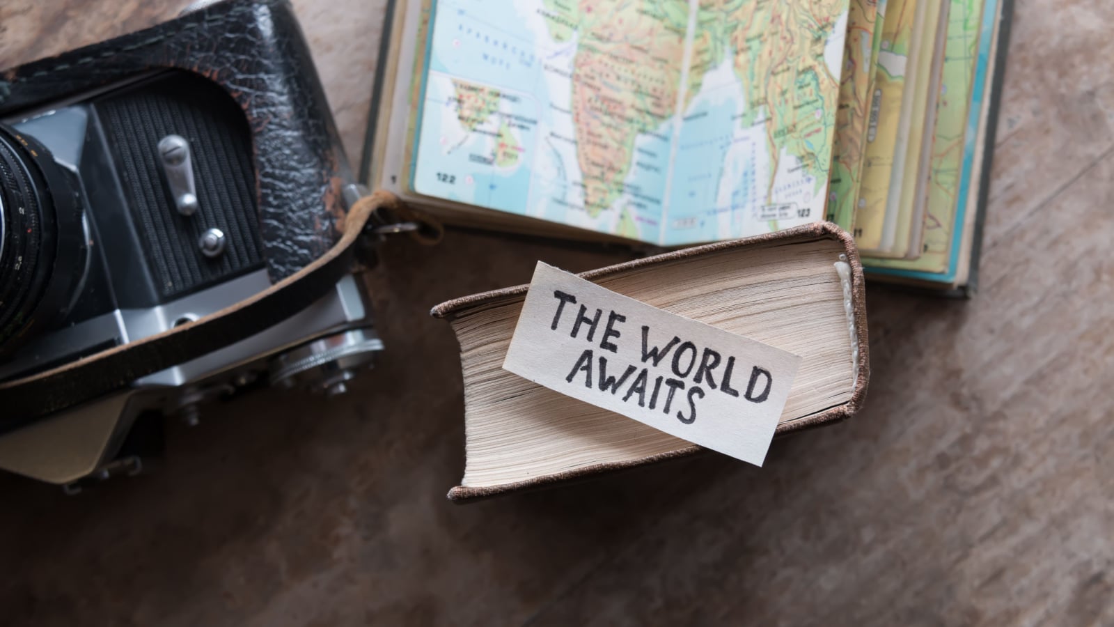 text "The World Awaits" and book, travel, tour, tourism concept