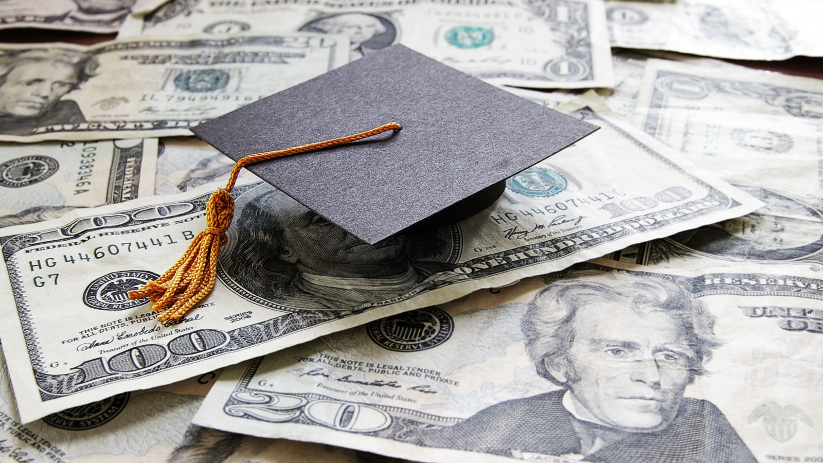 mini college graduation cap on cash