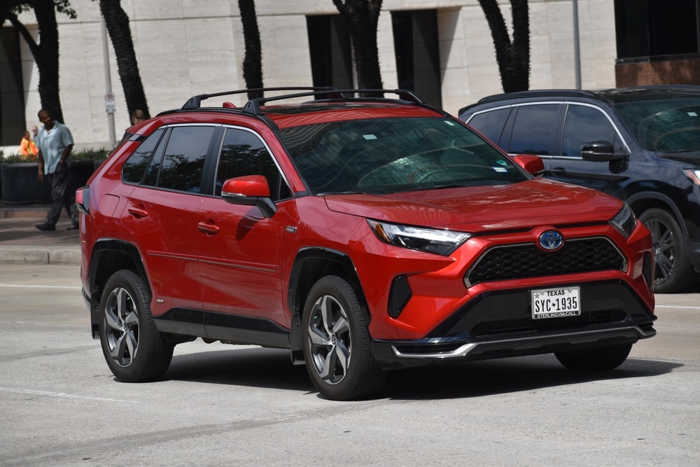 Houston, TX USA 5-15-2024 - A portrait of a red Toyota RAV4 Prime SUV cruising in a downtown financial district.