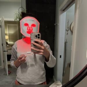 Lindsey of Have Clothes, WIll Travel wearing the CurrentBody LED Face mask in her bathroom