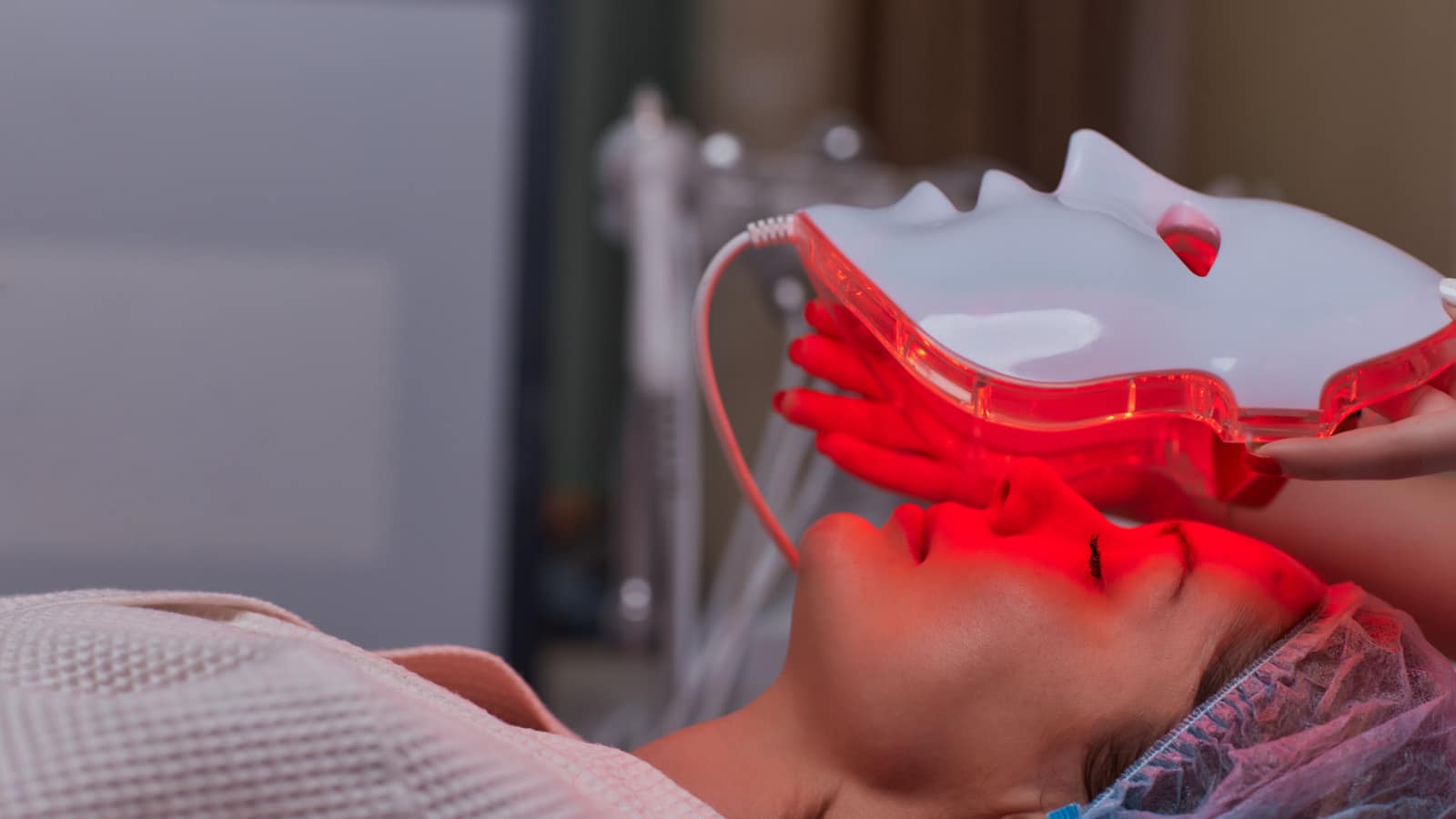 LED light anti-aging mask for facial skin care in a spa slow motion. A woman lies on a couch in a special mask. Modern technologies of beauty and health.