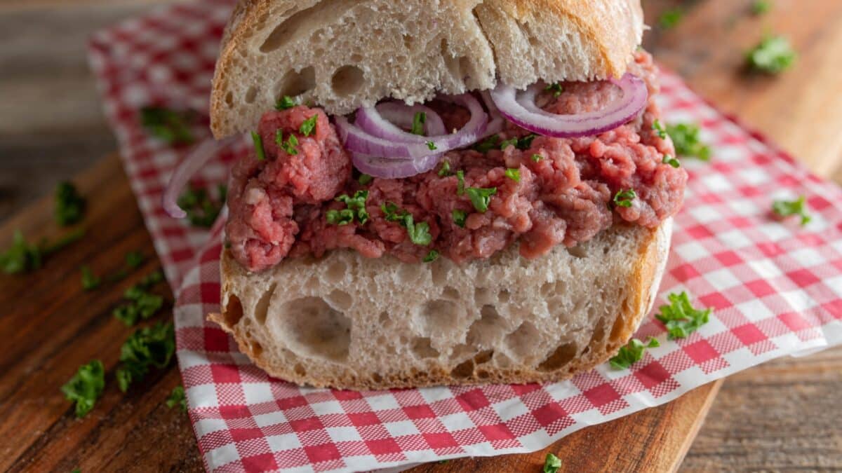 Tatar sandwich with red onions and parsley on a french baguette. Closeup and front view