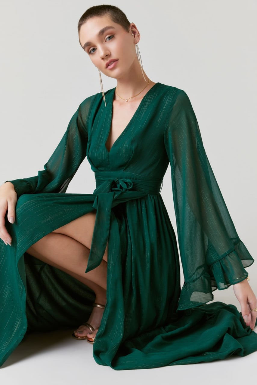 Elisa Long Flutter Sleeve Maxi Dress in Green with high slit and gold strappy sandals and long gold dangle earrings