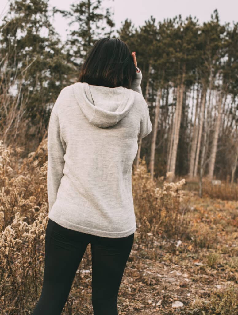 The back of Lindsey's grey alpaca hoodie and black leggings.