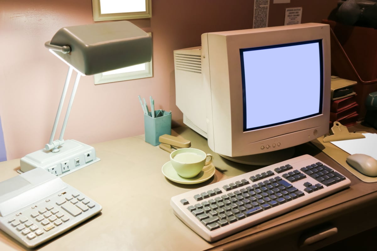 Retro interior office desk in dark room with simulator object.
