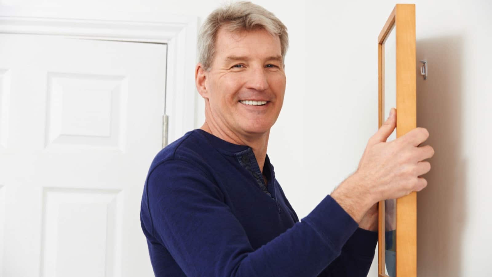 Man looking at hanging picture