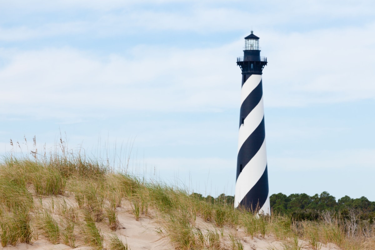 Cape Hatteras Lighthouse towers over beach dunes of Outer Banks island near Buxton, North Carolina, US