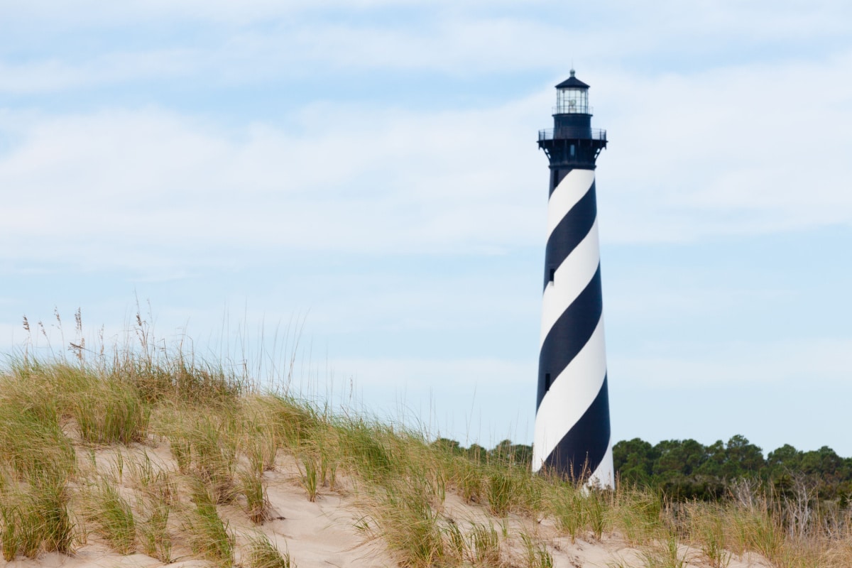Cape Hatteras Lighthouse towers over beach dunes of Outer Banks island near Buxton, North Carolina, US
