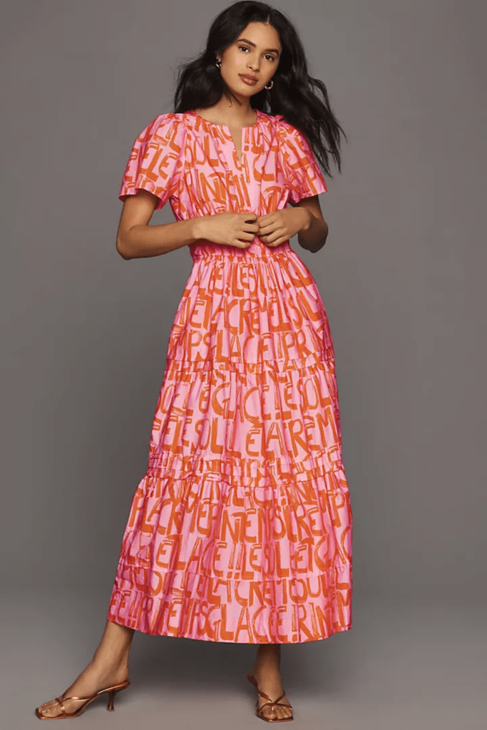 Model wearing a multicolor Somerset Maxi Dress in pink and red featuring a smocked waist