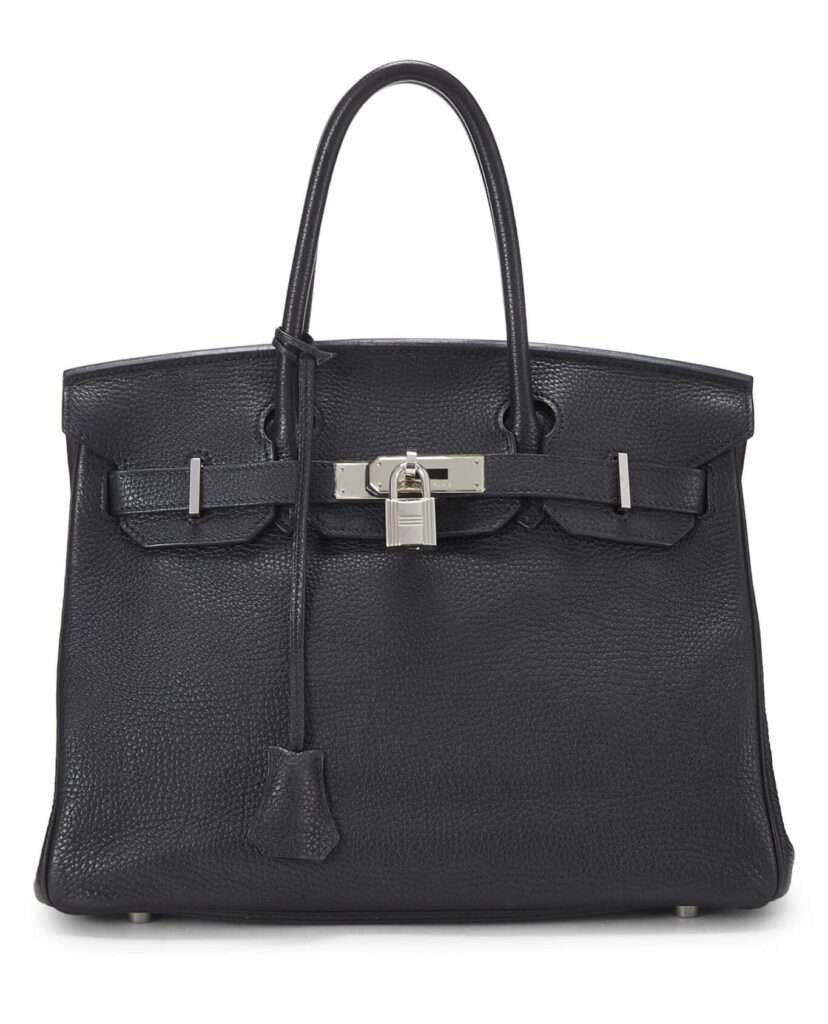 A black Birkin bag with silver hardware against a white backdrop 
