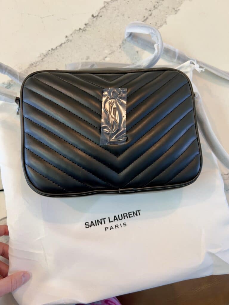 A black YSL Lou Camera Bag dupe with a white dust cover