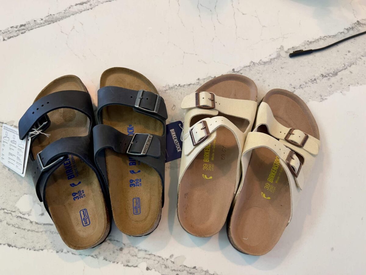 Two pairs of Birkenstock sandals side by side on a white countertop 
