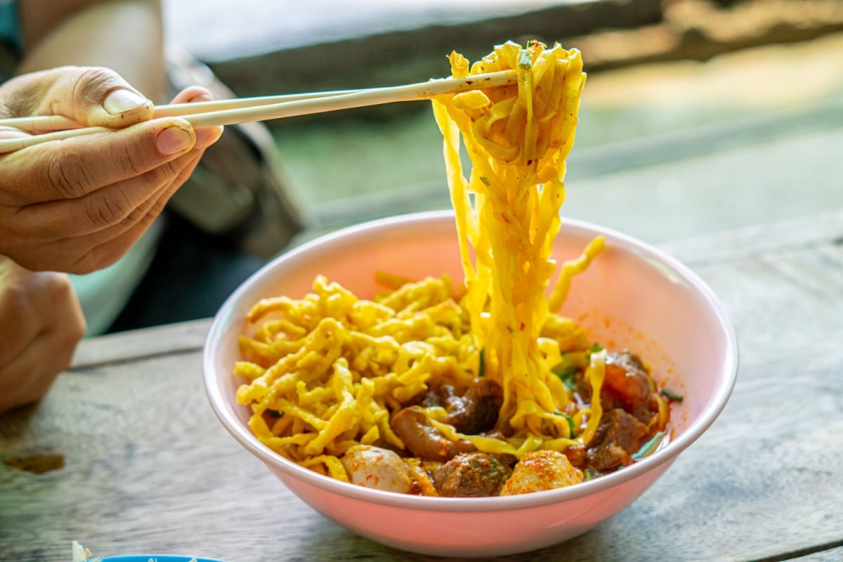 Khao Soi,Khao Soi Kai, Thai Noodles Khao Soi, Chicken Curry with seasoning on wooden floor, Northern Thai food concept. (Lanna food)