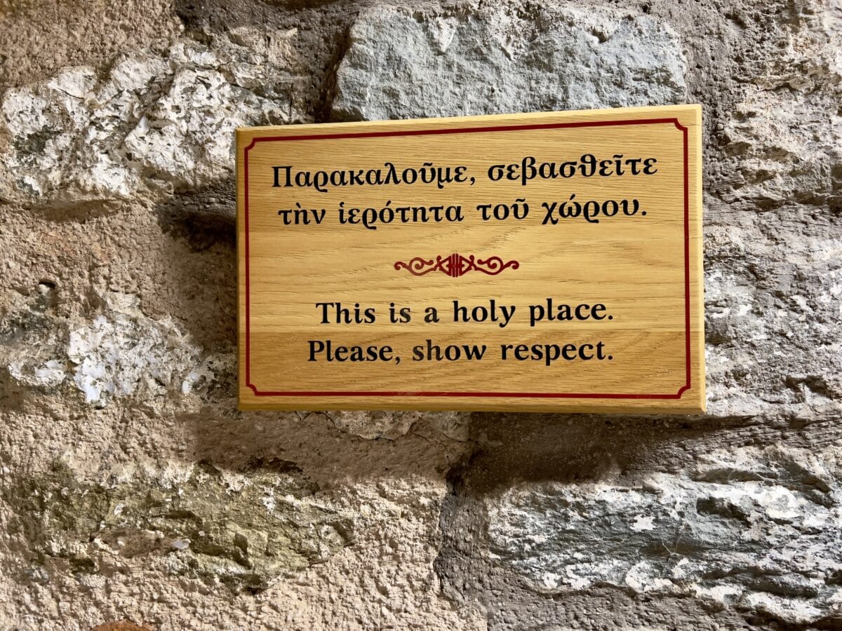 A sign in Meteora that says "This is a Holy place. Please, show respect."