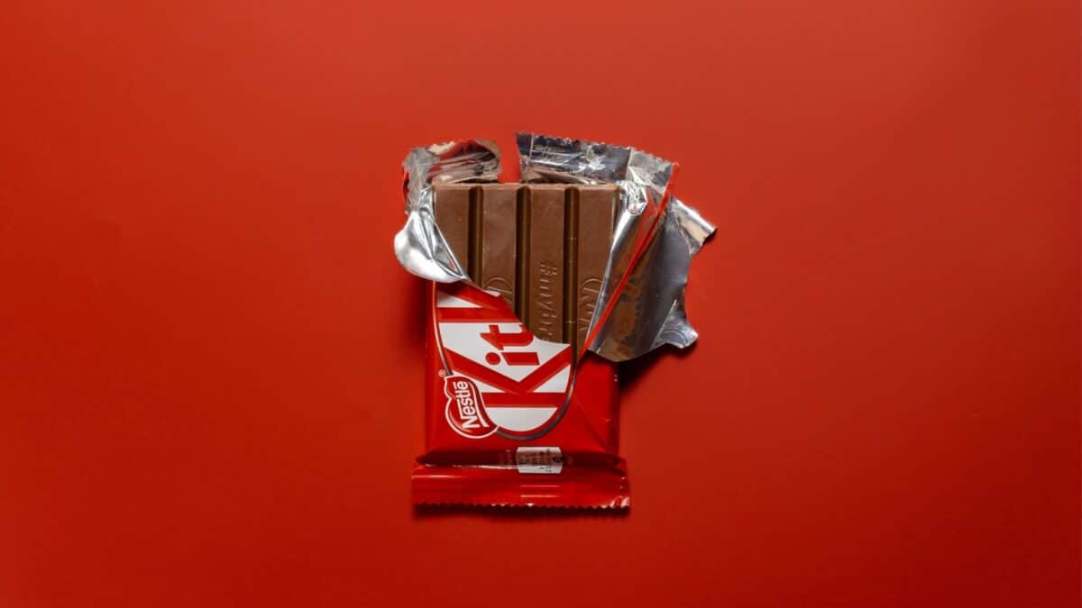 Kiev, Ukraine - November 30, 2019: Kitkat chocolate bar in open wrap on a red background.