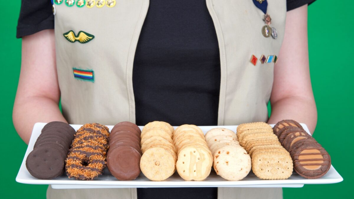 Alameda, CA - March 04, 2022: Cadette Girl Scout holding plate of Girl Scout cookies. Girl Scout cookie sales help girls learn marketing and money management skills