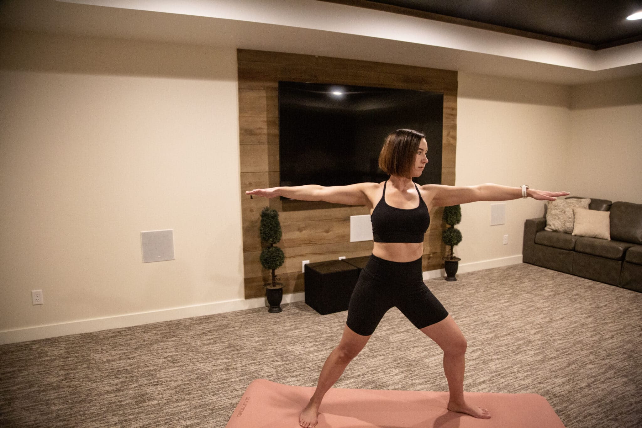 Lindsey wearing IUGA shorts and sports bra doing a yoga pose