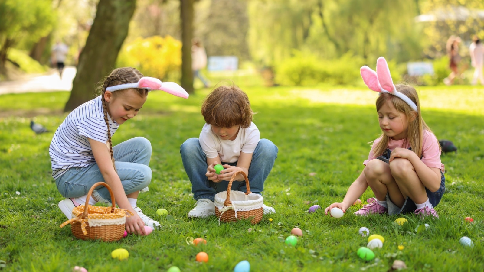 Easter celebration. Cute little children hunting eggs outdoors