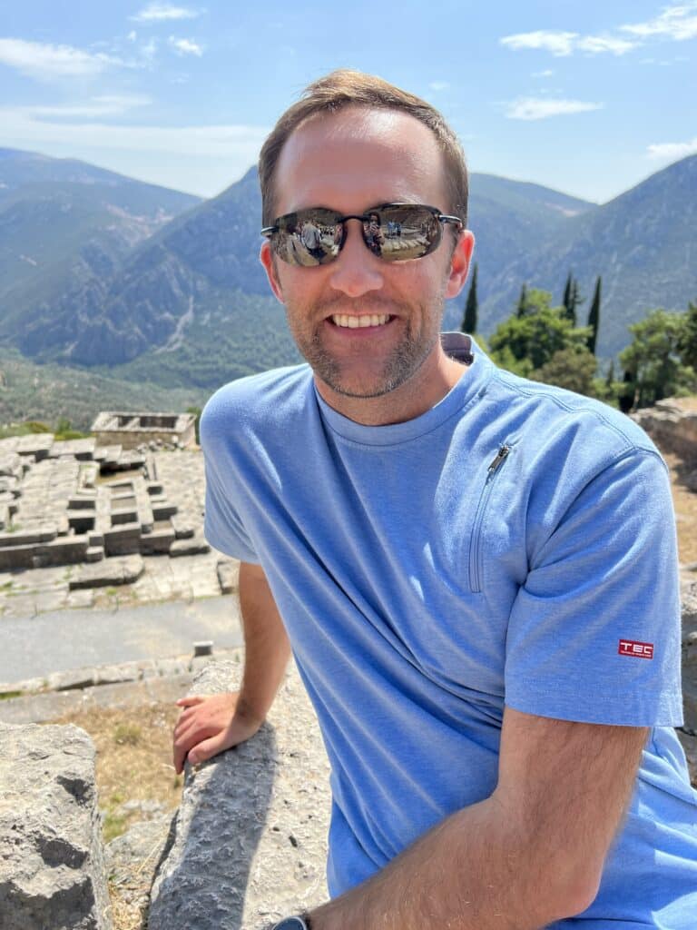 Zac wearing sunglasses and a blue shirt in Delphi, Greece.