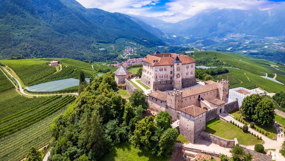 Medieval beautiful castles of northern Italy - splendid Thun castel amongst the apple trees of Val di Non. Trentino region, Trento province. Aerial drone panoramic view