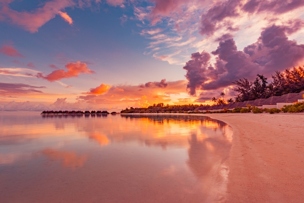 Amazing beach landscape. Beautiful Maldives sunset seascape view. Horizon colorful sea sky clouds, over water villa pier pathway. Tranquil island lagoon, tourism travel background. Exotic vacation