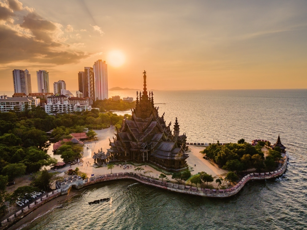 Skyline of Pattaya city at sunset with The Sanctuary of Truth wooden temple in Pattaya Thailand, gigantic wooden construction located at the cape of Naklua Pattaya City Chonburi Thailand