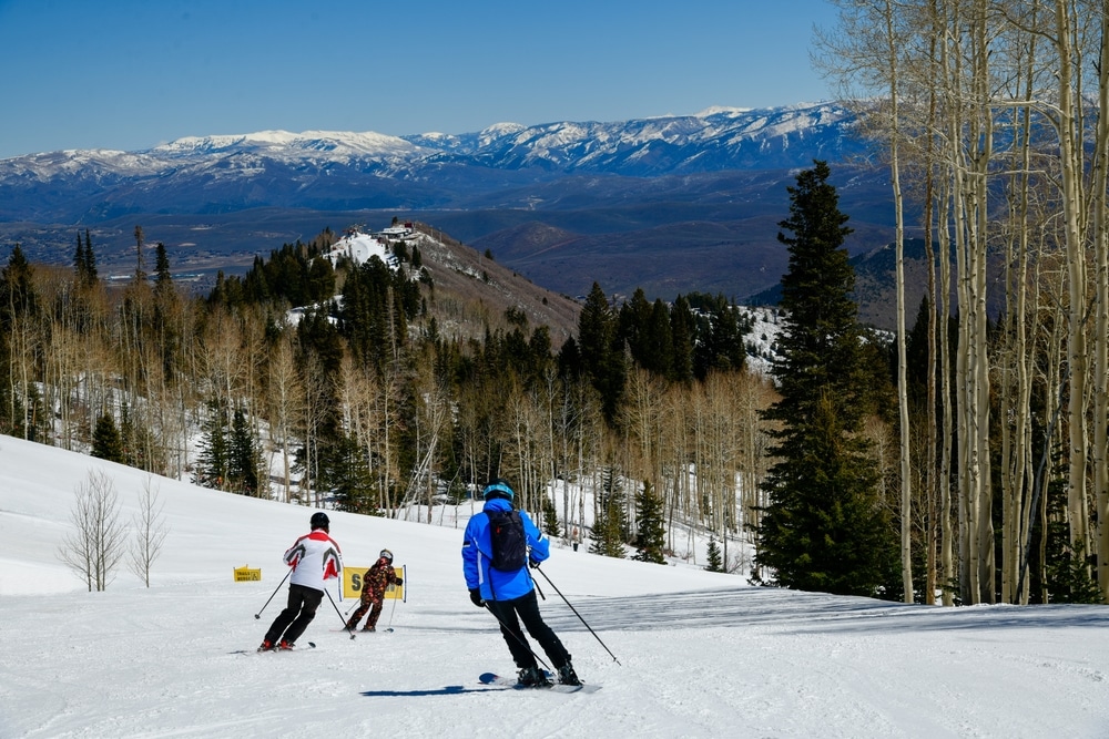 Enjoying skiing downhill at Park City Canyons Ski Area in Utah. Late spring weather conditions. Amazing sunny day and beautiful nature around.